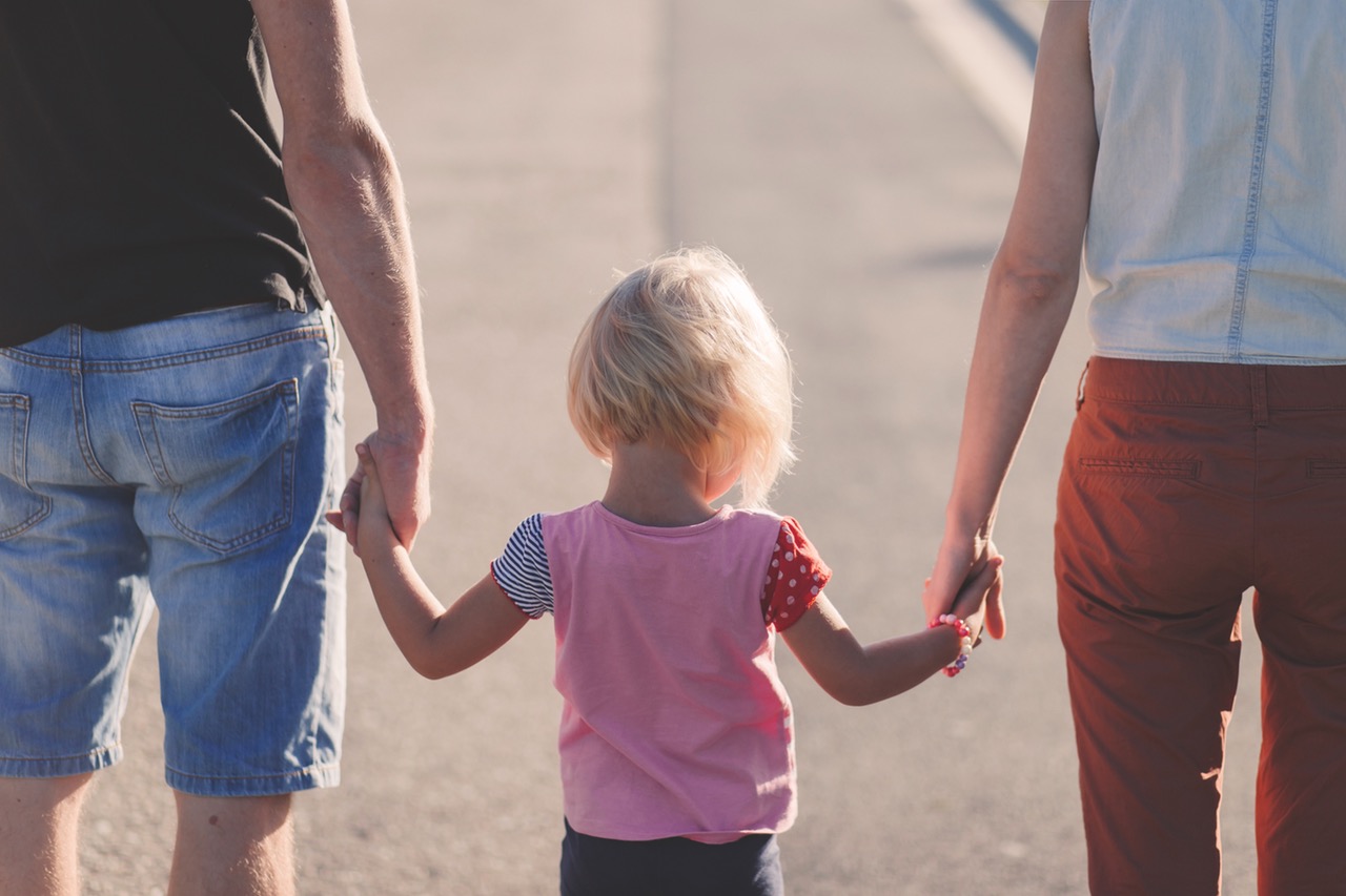 Child holding her parents hands